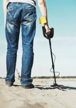 man-with-metal-detector-walks-along-the-sandy-rive-2023-11-27-05-22-54-utc